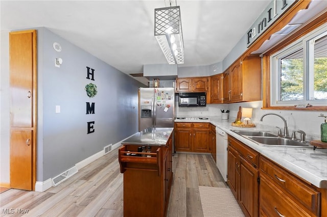 kitchen with visible vents, black microwave, stainless steel fridge with ice dispenser, dishwasher, and a sink