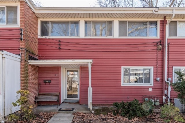 view of front of home with central AC and fence