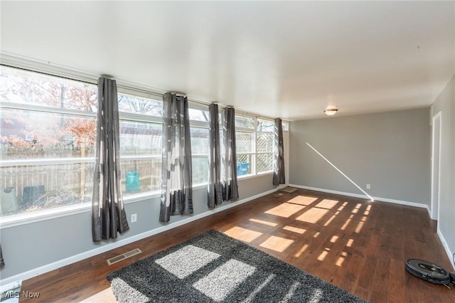 interior space with visible vents, baseboards, and wood finished floors