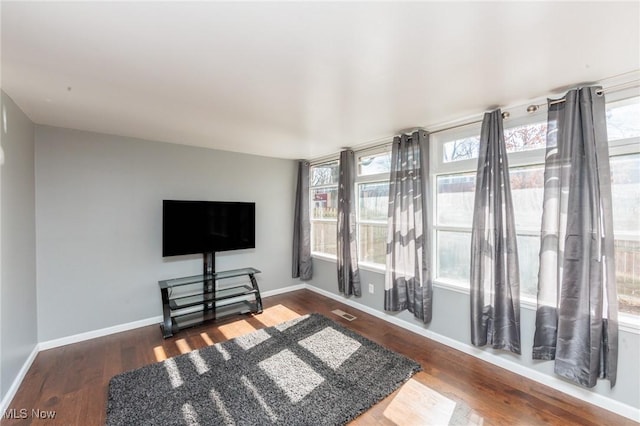 living area with baseboards and wood finished floors