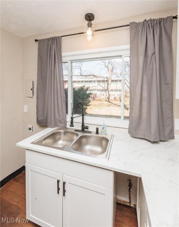 kitchen with a sink, white cabinets, and light countertops