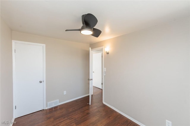 unfurnished room featuring a ceiling fan, wood finished floors, visible vents, and baseboards