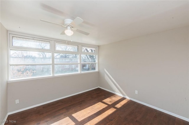 spare room featuring a ceiling fan, baseboards, and wood finished floors