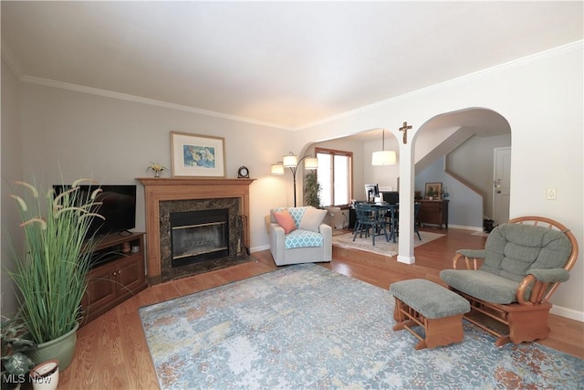 living area with wood finished floors, arched walkways, and a premium fireplace