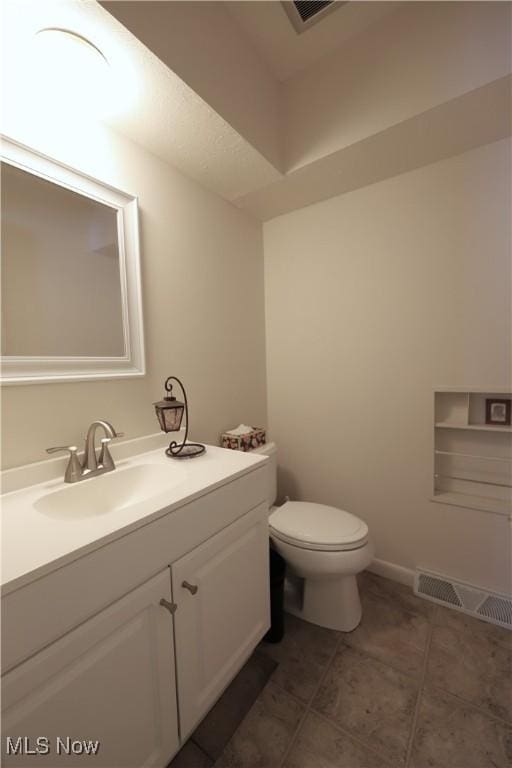 bathroom featuring tile patterned floors, visible vents, toilet, and vanity