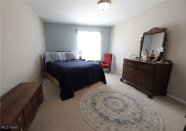 bedroom with light colored carpet and baseboards