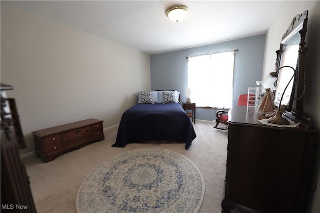 bedroom featuring baseboards and light carpet