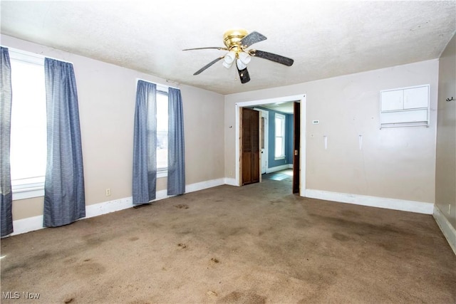 spare room with ceiling fan, a textured ceiling, baseboards, and carpet floors