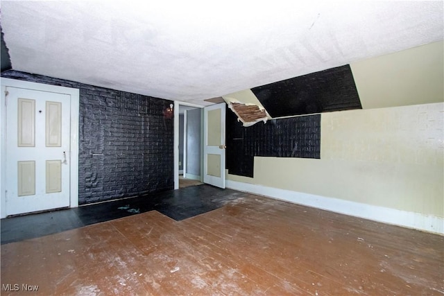 empty room with wood finished floors, baseboards, and a textured ceiling