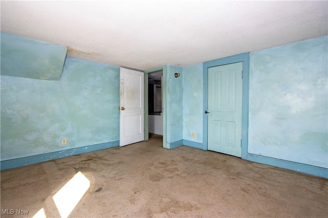 unfurnished room with baseboards and carpet floors