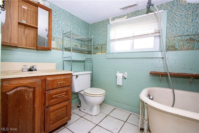 full bath with vanity, visible vents, wallpapered walls, tile walls, and toilet