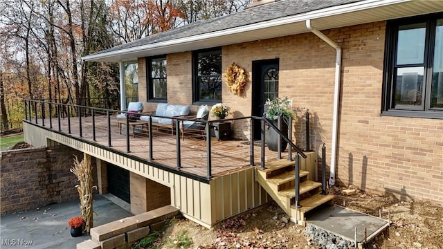 wooden terrace with an outdoor hangout area and a garage