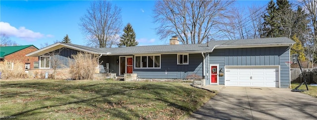 ranch-style home with driveway, board and batten siding, a front yard, a garage, and a chimney