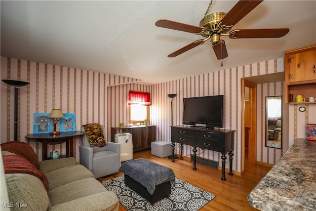 living area with light wood-style floors and wallpapered walls