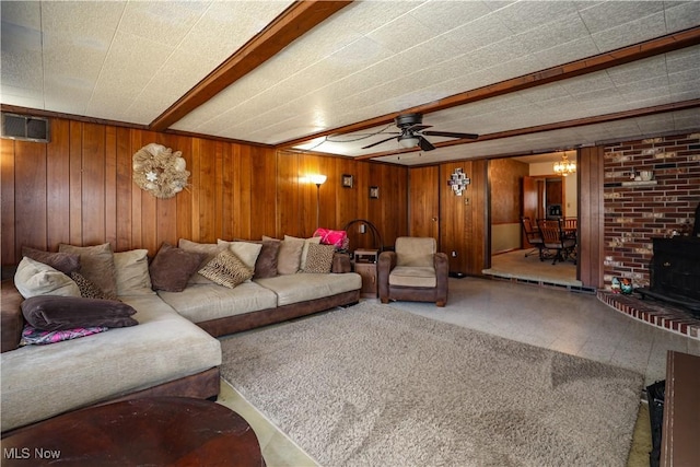 living area with visible vents, wood walls, and ceiling fan