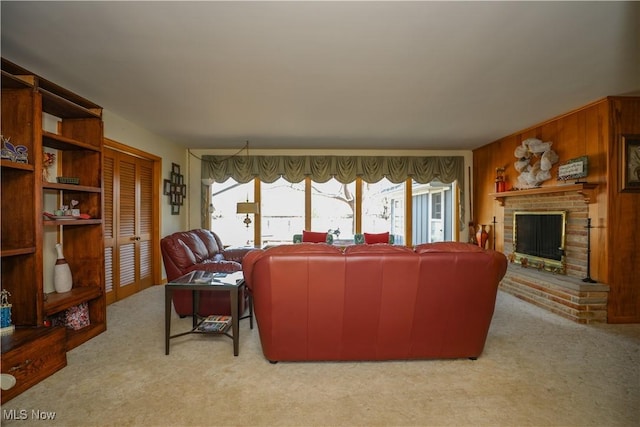 carpeted living room with wooden walls and a fireplace