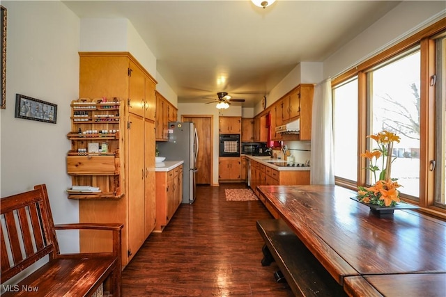 kitchen featuring under cabinet range hood, dark wood-style floors, black appliances, and light countertops