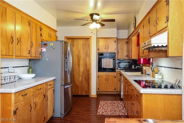 kitchen featuring decorative backsplash, black appliances, light countertops, and under cabinet range hood