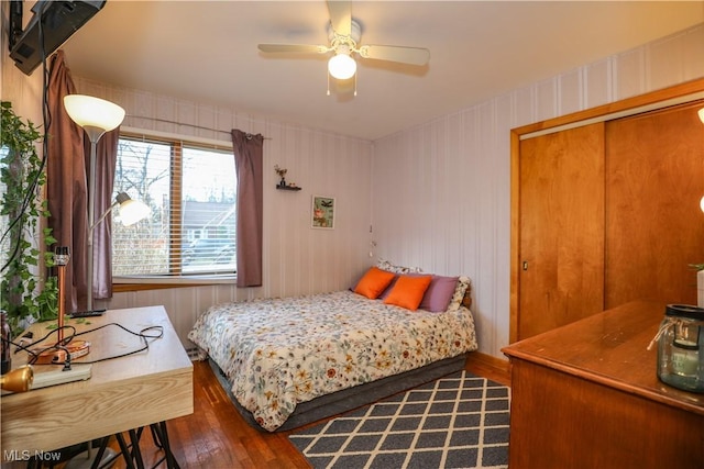 bedroom featuring a ceiling fan, wood finished floors, and a closet