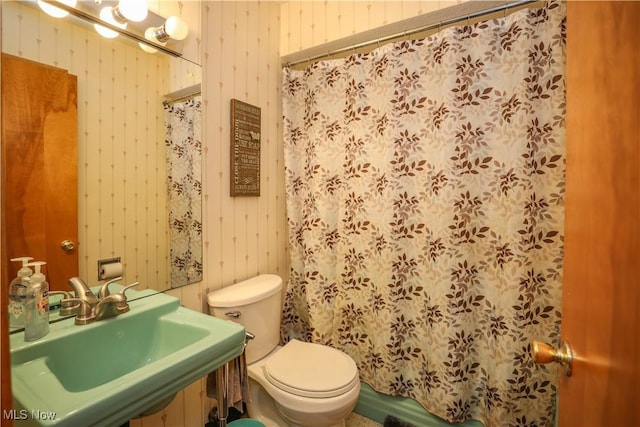 bathroom featuring a sink, a shower with curtain, and toilet