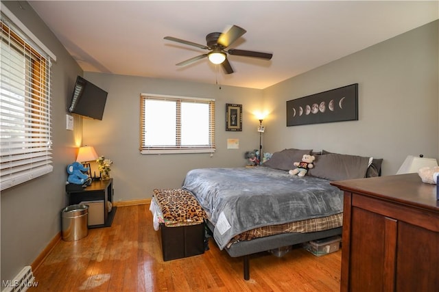 bedroom featuring baseboards, light wood-style floors, and a ceiling fan