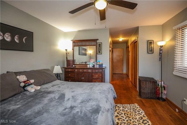 bedroom with baseboards, ceiling fan, and wood finished floors