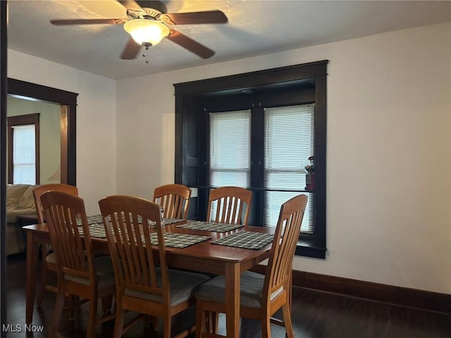 dining area with a ceiling fan, plenty of natural light, wood finished floors, and baseboards