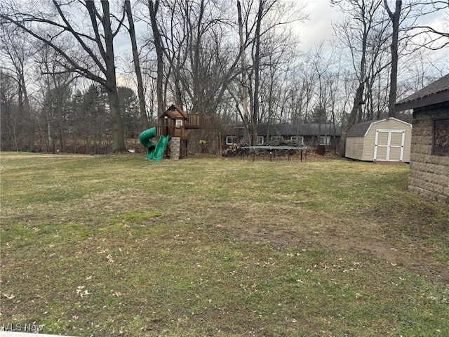 view of yard with a storage unit, a playground, an outdoor structure, and a trampoline