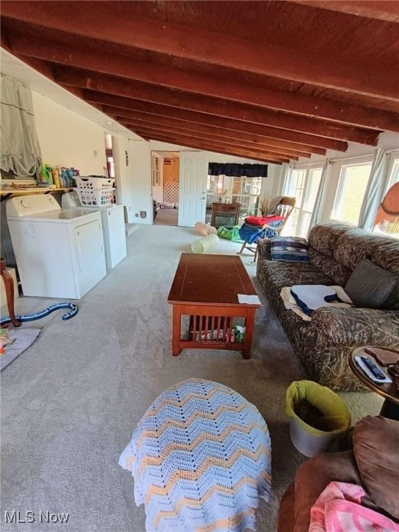 carpeted living room featuring washer and dryer and beamed ceiling