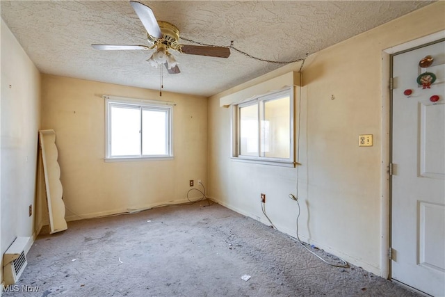 spare room featuring a textured ceiling and a ceiling fan