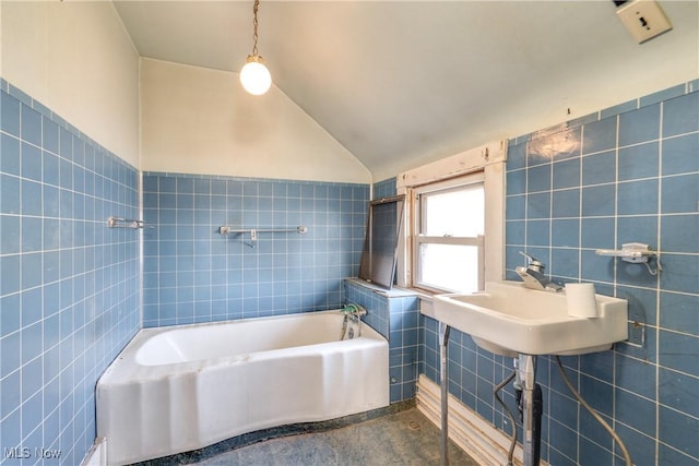 bathroom with a bathing tub, tile walls, and vaulted ceiling