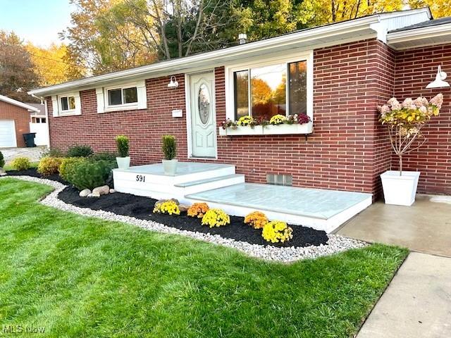 view of front of home with a front lawn and brick siding