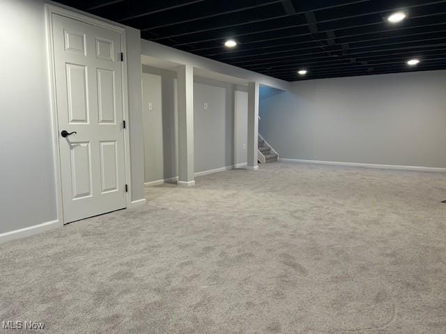 finished below grade area featuring recessed lighting, carpet flooring, baseboards, and stairs