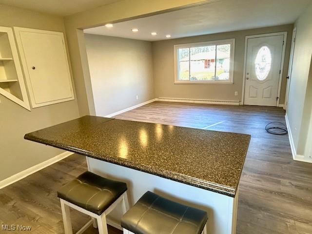 kitchen with baseboards, dark countertops, white cabinets, and dark wood-style flooring