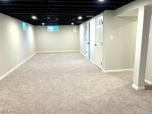 below grade area featuring baseboards and carpet floors