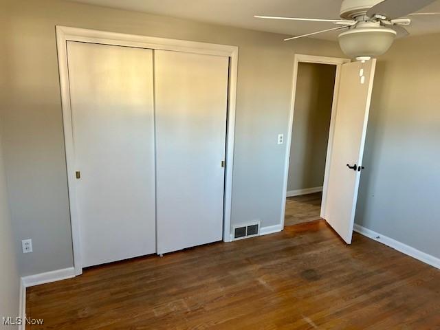 unfurnished bedroom featuring visible vents, baseboards, and wood finished floors