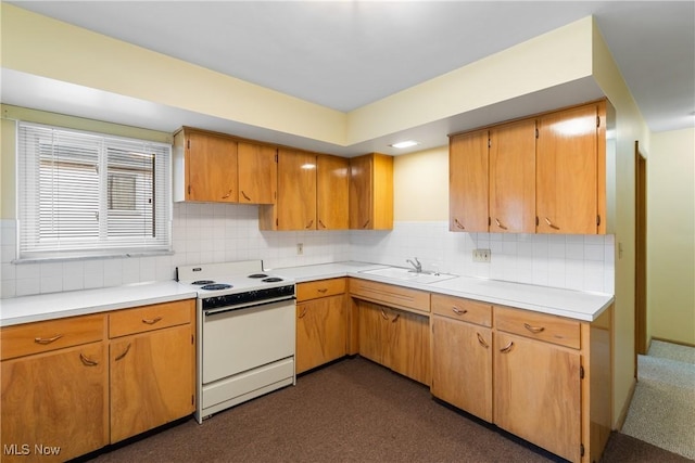 kitchen with a sink, light countertops, decorative backsplash, and white range with electric stovetop