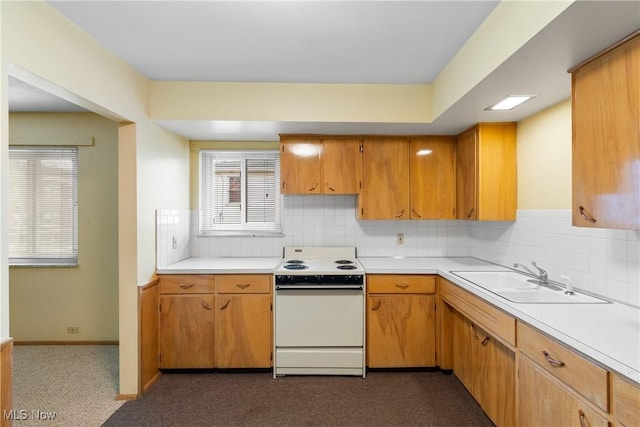 kitchen featuring a sink, tasteful backsplash, light countertops, and electric stove