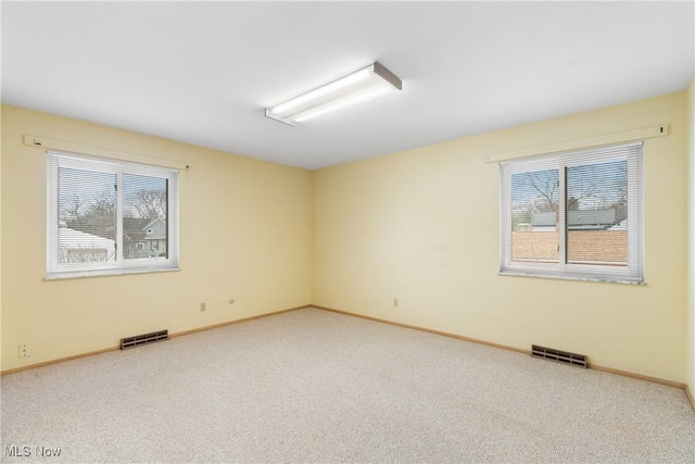 unfurnished room with visible vents, baseboards, and carpet