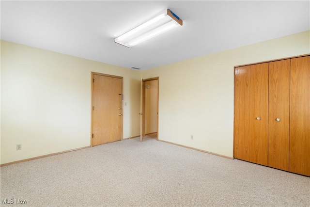 unfurnished bedroom featuring visible vents, baseboards, and light colored carpet