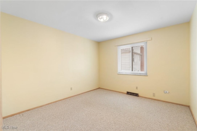 unfurnished room featuring visible vents, carpet flooring, and baseboards