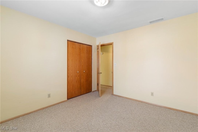 unfurnished room with visible vents, baseboards, and light carpet