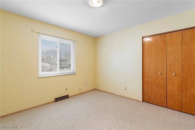 unfurnished bedroom featuring a closet, visible vents, carpet flooring, and baseboards