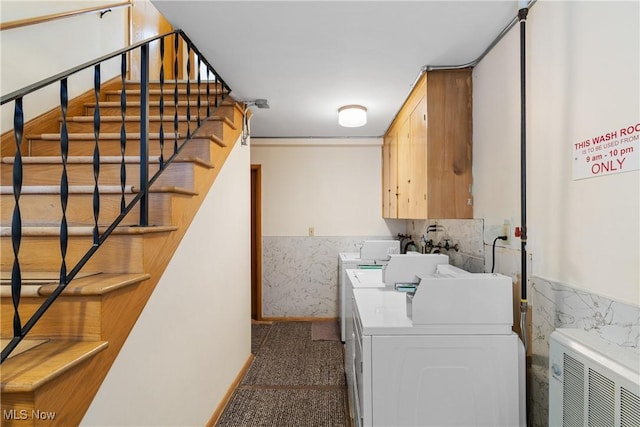 laundry area with separate washer and dryer, a wainscoted wall, cabinet space, and carpet