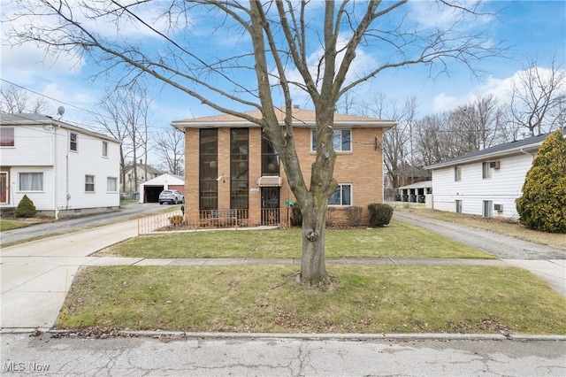 view of front of property featuring a front lawn and brick siding