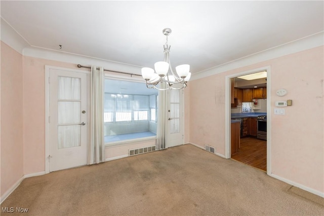 unfurnished dining area featuring visible vents, an inviting chandelier, baseboards, and carpet