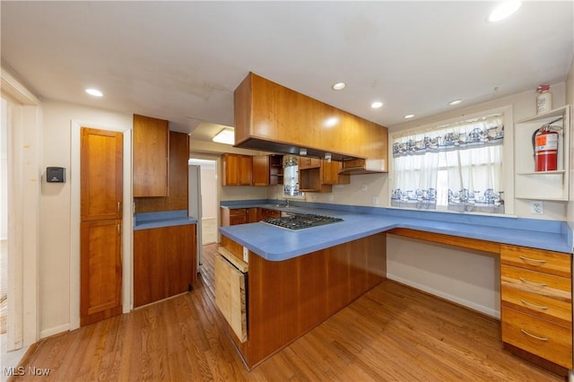 kitchen featuring brown cabinetry, recessed lighting, a peninsula, and light wood-type flooring