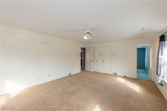 empty room featuring light carpet, visible vents, and a ceiling fan