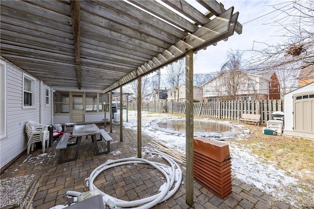 view of patio with an outdoor structure, a storage unit, a fenced backyard, and a pergola