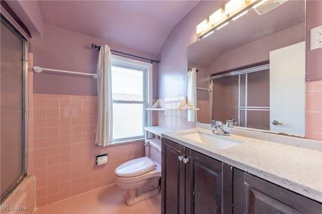 bathroom featuring visible vents, a wainscoted wall, toilet, vanity, and tile walls